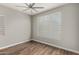 Bedroom features wood floors, neutral walls, a large window with blinds, and a ceiling fan at 21127 W Minnezona Ave, Buckeye, AZ 85396