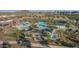 Aerial view of a luxurious community pool area with palm trees, shaded seating, and well-maintained landscaping at 21127 W Minnezona Ave, Buckeye, AZ 85396