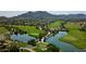 Picturesque aerial view of a lush golf course with scenic pond, mature trees, and well-manicured greenways at 21127 W Minnezona Ave, Buckeye, AZ 85396