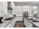 Well-lit kitchen featuring stainless steel appliances, white cabinets, dark countertops, and tile backsplash at 21127 W Minnezona Ave, Buckeye, AZ 85396