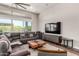 Bright living room features a modern ceiling fan, comfortable seating, and a large television at 21127 W Minnezona Ave, Buckeye, AZ 85396