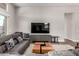 Spacious living room featuring a comfortable sofa, sleek entertainment center, and neutral decor at 21127 W Minnezona Ave, Buckeye, AZ 85396