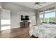 Main bedroom boasts wood floors, large windows with views, TV, dresser, and ceiling fan at 21127 W Minnezona Ave, Buckeye, AZ 85396