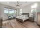 Spacious main bedroom with wood floors, large windows with natural light, and a ceiling fan at 21127 W Minnezona Ave, Buckeye, AZ 85396