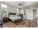 Bright main bedroom featuring wood floors, multiple windows, ceiling fan, and ensuite bathroom access at 21127 W Minnezona Ave, Buckeye, AZ 85396