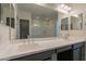 Contemporary bathroom featuring double sinks, gray cabinets and a glass-enclosed shower at 2205 S 241St Dr, Buckeye, AZ 85326