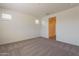 Bedroom featuring two windows, neutral walls, a shower through a door, and carpet flooring at 2205 S 241St Dr, Buckeye, AZ 85326