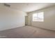 Bright bedroom with carpet, window with blinds, neutral walls, and an open doorway at 2205 S 241St Dr, Buckeye, AZ 85326
