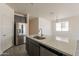 Modern kitchen with stainless steel appliances, gray cabinetry, and a large center island at 2205 S 241St Dr, Buckeye, AZ 85326