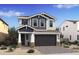 Charming two-story home with gray and white siding, complemented by a spacious two-car garage and a landscaped front yard at 2381 W Los Arboles Pl, Chandler, AZ 85224