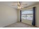 This bedroom features a ceiling fan and one arched window facing the street at 2405 W Cordia Ln, Phoenix, AZ 85085
