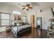 This main bedroom features a ceiling fan, wood floors, and access to the main bathroom at 2405 W Cordia Ln, Phoenix, AZ 85085