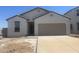New construction home with a two-car garage, a modern white exterior, and drought-resistant landscaping at 24252 W Pecan Rd, Buckeye, AZ 85326