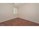 An empty bedroom with wood-look floors, neutral walls, and bright window at 2845 N 104Th Ave, Avondale, AZ 85392