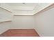 Organized walk-in closet with wood shelving and laminate flooring at 2845 N 104Th Ave, Avondale, AZ 85392