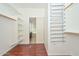 Spacious walk-in closet with built-in shelving, shoe racks, and laminate flooring at 2845 N 104Th Ave, Avondale, AZ 85392