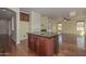 Kitchen island with dark wood cabinets and granite countertop overlooking the open floor plan at 2845 N 104Th Ave, Avondale, AZ 85392