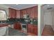 Gourmet kitchen with dark wood cabinetry, stainless steel appliances and sleek granite countertops at 2845 N 104Th Ave, Avondale, AZ 85392