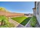 Backyard view showcasing lush landscaping, a small artificial lawn, and a brick perimeter fence at 31435 N 130Th Ave, Peoria, AZ 85383