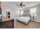 Bright bedroom featuring a walk-in closet, wood-look tile flooring, and a ceiling fan at 31435 N 130Th Ave, Peoria, AZ 85383