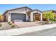 Inviting single-story home featuring desert landscaping, a gray two-car garage and a brick driveway at 31435 N 130Th Ave, Peoria, AZ 85383