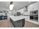 Bright kitchen with an island with a black base, white countertop, and modern pendant lighting at 31435 N 130Th Ave, Peoria, AZ 85383