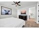 Cozy bedroom featuring wood-look floors, a dresser with TV, and artwork at 31435 N 130Th Ave, Peoria, AZ 85383