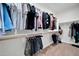 Well-organized walk-in closet with ample hanging space, shelving, and wood look tile flooring at 31435 N 130Th Ave, Peoria, AZ 85383