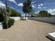 Expansive backyard with desert landscaping, a privacy fence, and mature trees, offering ample space for outdoor activities at 3225 E Monica Ave, Phoenix, AZ 85032