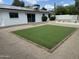 Private backyard with artificial turf, low-maintenance landscaping, and a brick-paved patio, perfect for outdoor gatherings at 3225 E Monica Ave, Phoenix, AZ 85032