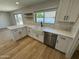Bright kitchen features white cabinets, stainless steel appliances, a farmhouse sink, and wood-look floors at 3225 E Monica Ave, Phoenix, AZ 85032
