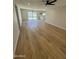 Bright living room with wood flooring, neutral walls, and sliding glass doors leading to the backyard at 3225 E Monica Ave, Phoenix, AZ 85032