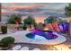 Backyard pool illuminated with vibrant colors surrounded by desert landscaping and a privacy wall at 3379 E San Pedro Ave, Gilbert, AZ 85234