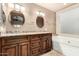 Bathroom featuring double sinks with granite countertops and a soaking tub at 3379 E San Pedro Ave, Gilbert, AZ 85234