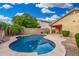 Desert landscaped backyard with a pool and a covered patio at 3379 E San Pedro Ave, Gilbert, AZ 85234