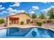 Desert landscaped backyard with a pool and a covered patio at 3379 E San Pedro Ave, Gilbert, AZ 85234