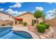 Desert landscaped backyard with a pool and a covered patio at 3379 E San Pedro Ave, Gilbert, AZ 85234