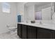 Bathroom featuring double sinks, dark cabinets, and a large mirror at 37103 N El Morro Trl, San Tan Valley, AZ 85140