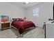 Bedroom with wood-look tile, ceiling fan, and a red comforter at 37103 N El Morro Trl, San Tan Valley, AZ 85140