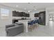 Modern kitchen featuring an island with seating, dark cabinetry, stainless steel appliances, and open layout at 37103 N El Morro Trl, San Tan Valley, AZ 85140