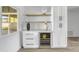 Stylish bar area featuring white cabinets, wine cooler, and floating shelves at 3904 S Butte Ave, Tempe, AZ 85282