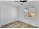 Bright bedroom with modern ceiling fan, light wood floors, and view to a fenced backyard at 3904 S Butte Ave, Tempe, AZ 85282