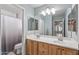 Light and airy bathroom featuring a double sink vanity, a large mirror, and a shower at 396 S 166Th Dr, Goodyear, AZ 85338