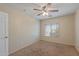 Cozy carpeted bedroom with a ceiling fan and natural light from a window at 396 S 166Th Dr, Goodyear, AZ 85338