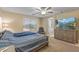 Comfortable bedroom with window, ceiling fan, dresser with TV, and attached bath at 396 S 166Th Dr, Goodyear, AZ 85338