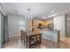 Bright, open kitchen features stainless appliances, natural wood cabinetry, and dining table with elegant lighting at 396 S 166Th Dr, Goodyear, AZ 85338
