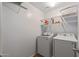 A bright laundry room with washer, dryer, and wire shelving at 396 S 166Th Dr, Goodyear, AZ 85338