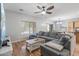 Inviting living room featuring comfortable gray sofa, ceiling fan, a large tv and natural lighting at 396 S 166Th Dr, Goodyear, AZ 85338