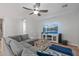 Living room with a large gray sectional, ceiling fan, and a view of the television at 396 S 166Th Dr, Goodyear, AZ 85338