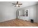 Living room with wood laminate flooring, white trim cabinets, and a ceiling fan at 396 S 166Th Dr, Goodyear, AZ 85338